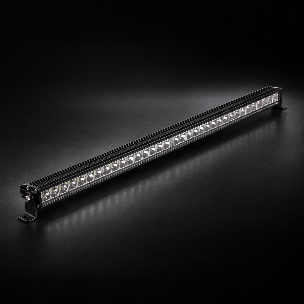 32 inch Whipped 4WD RGB LED light bar, lights off, black aluminium housing and end brackets on a dark studio floor